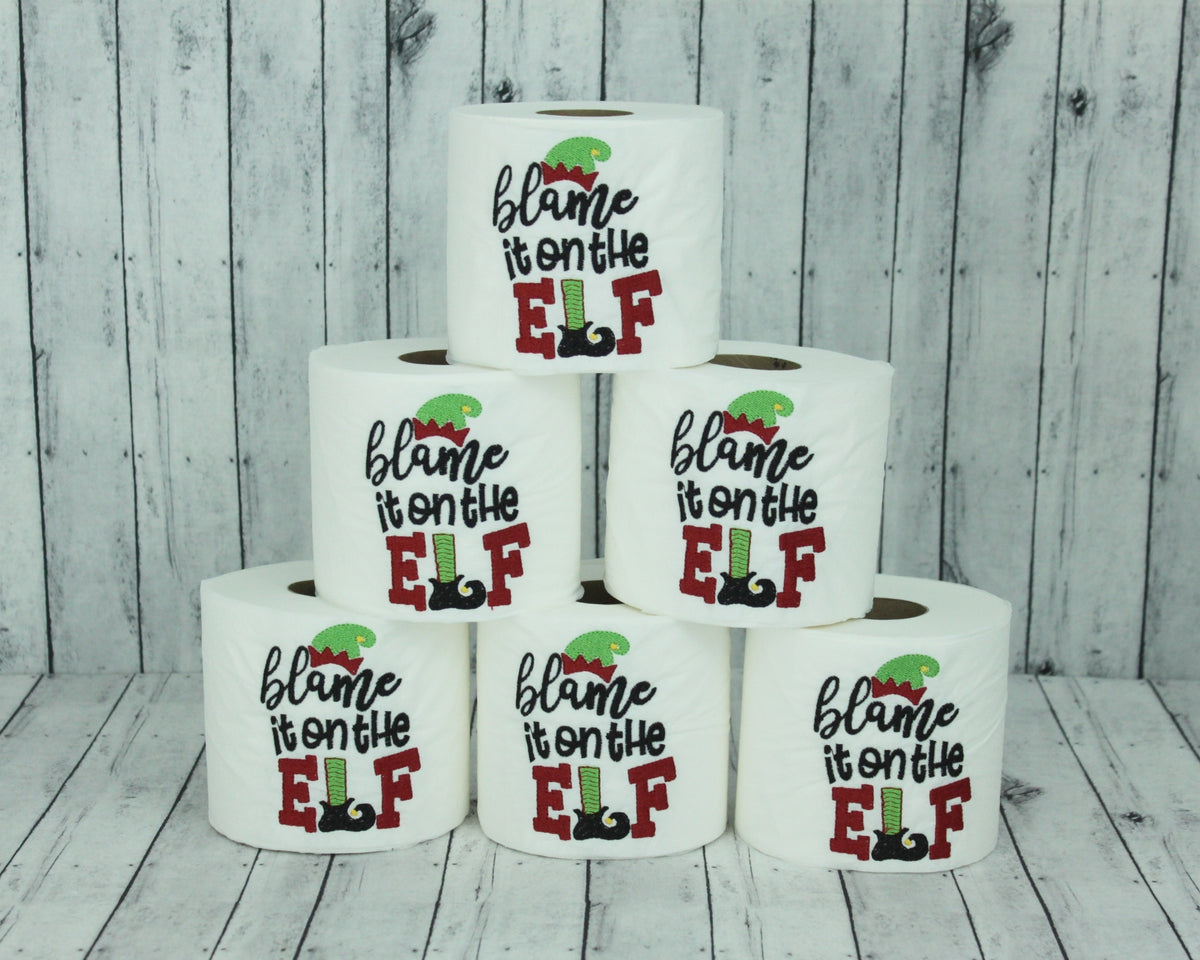 Stack of blame it on the elf embroidered toilet paper rolls