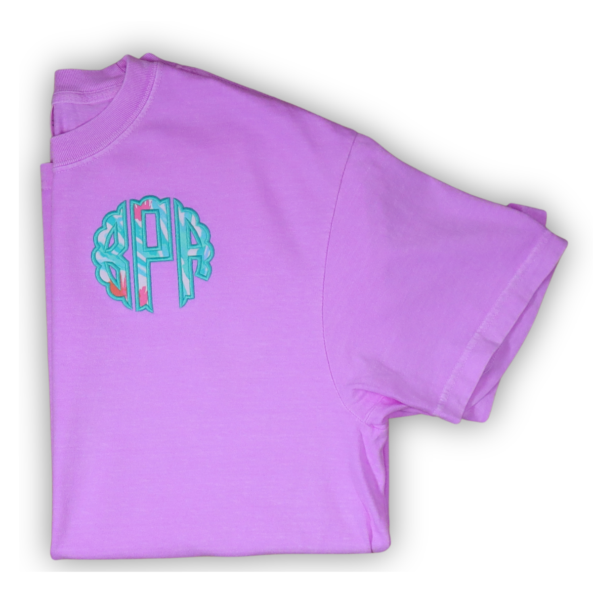 Folded purple t-shirt with a colorful monogram on a white background